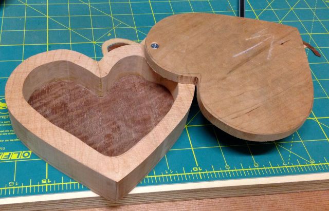 The lid swings open and the inside bottom has a veneer applied to it.