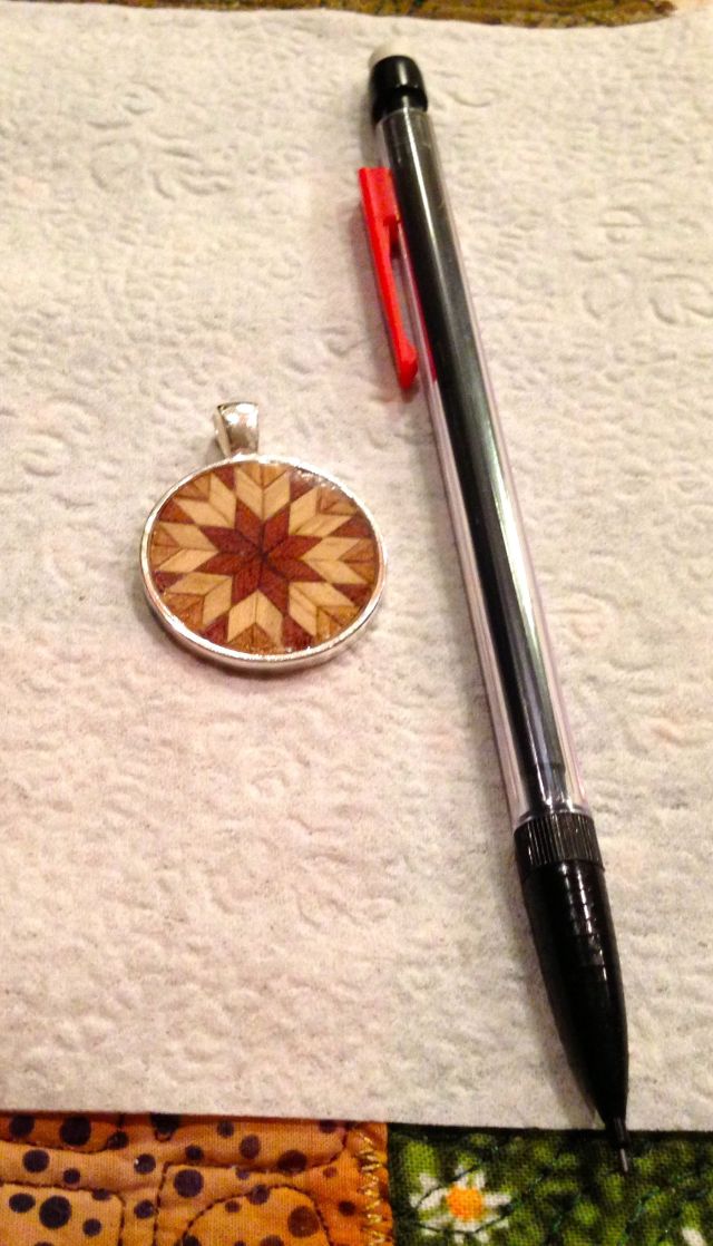 Parquetry set in a pendant bezel and sealed with polyester resin.